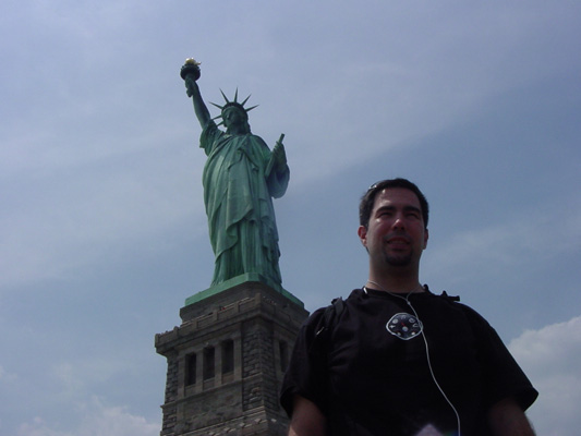 Tom standing in front of the Statue of Liberty.